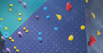Prises escalade jaunes bleues rouges mauves sur mur bleu Prises escalade jaunes bleues rouges mauves sur mur bleu